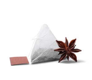 Photo of New tea bag with label and anise star on white background