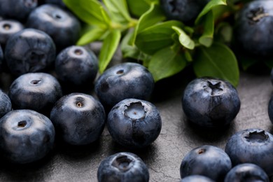 Photo of Tasty fresh blueberries on grey table, closeup