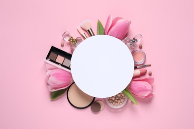 Flat lay composition with different makeup products, blank card and beautiful tulips on pink background, space for text