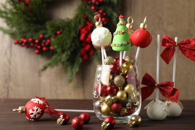 Photo of Delicious Christmas themed cake pops on wooden table
