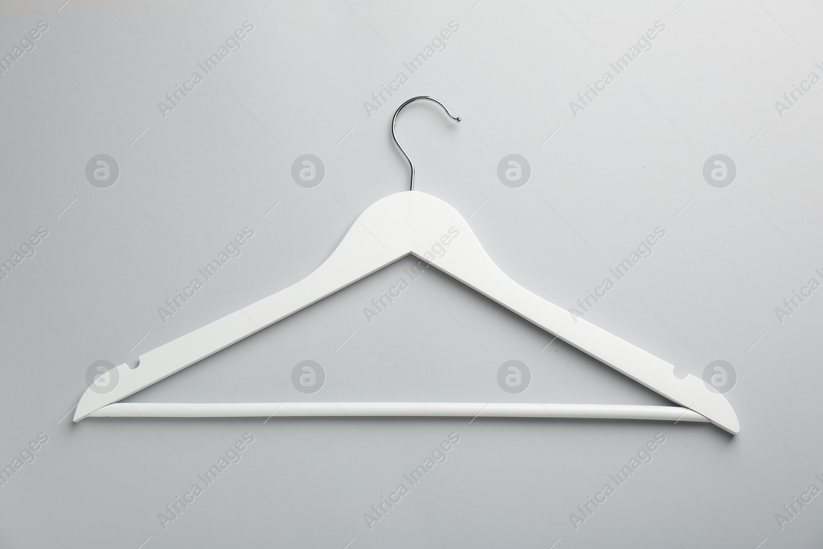 Photo of White hanger on light gray background, top view
