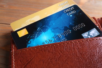 Credit cards in leather wallet on wooden table, closeup