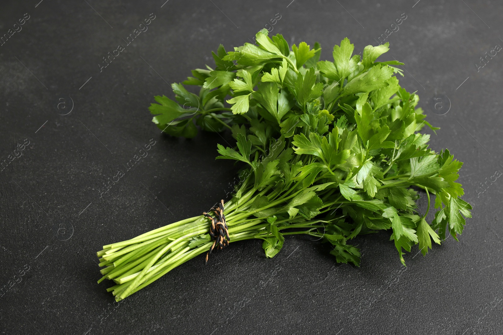 Photo of Bunch of fresh green parsley on black background