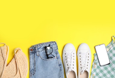 Photo of Set of stylish clothes and smartphone on yellow background, flat lay. Space for text