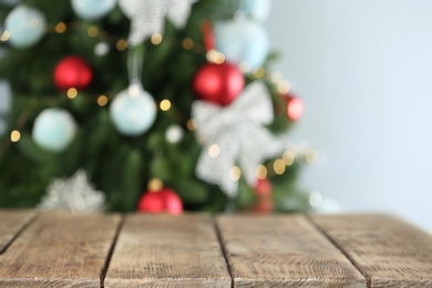 Photo of Empty wooden table and blurred fir tree with Christmas lights on background, bokeh effect. Space for design