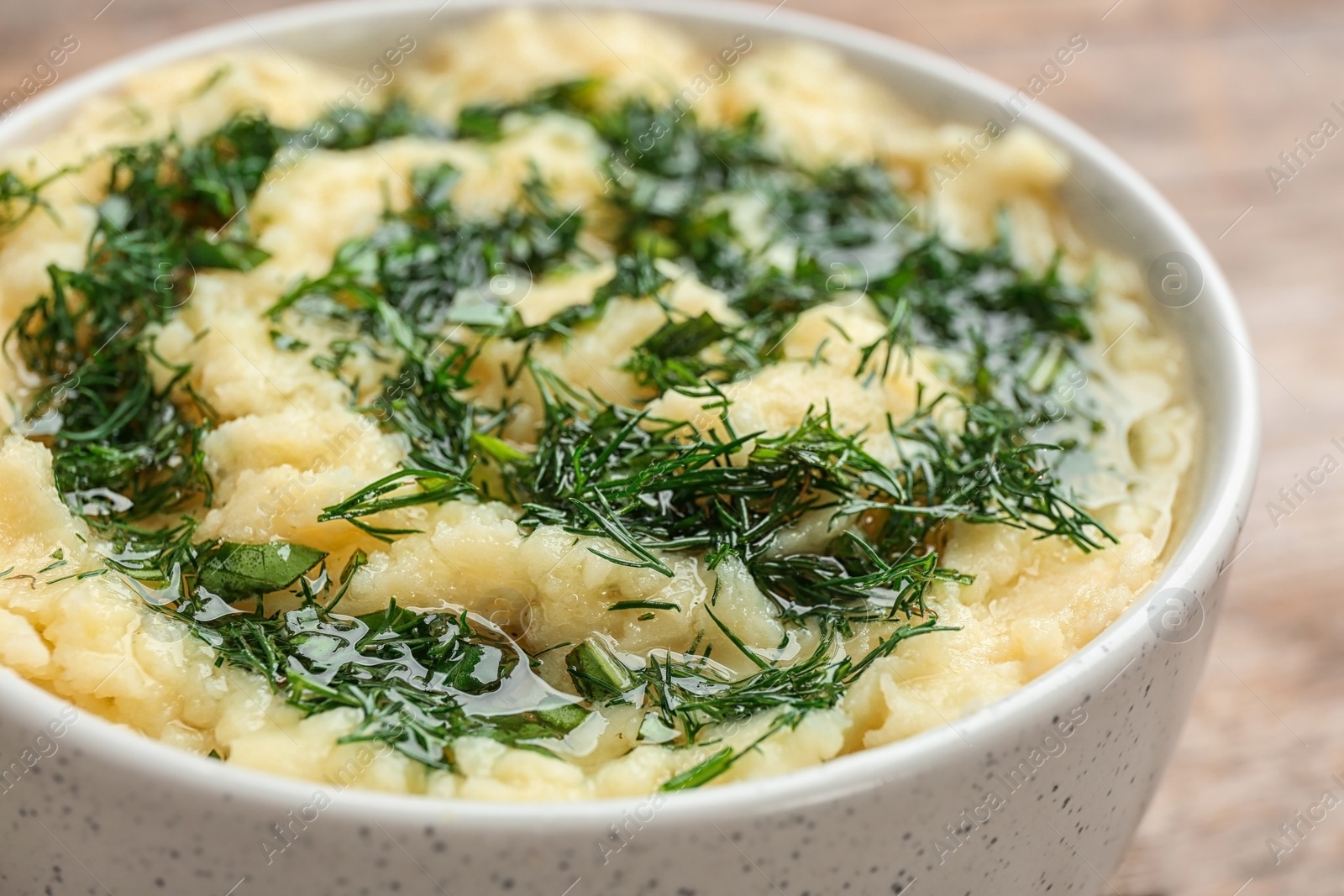 Photo of Bowl with tasty mashed potato on table, closeup