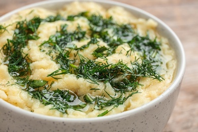 Photo of Bowl with tasty mashed potato on table, closeup