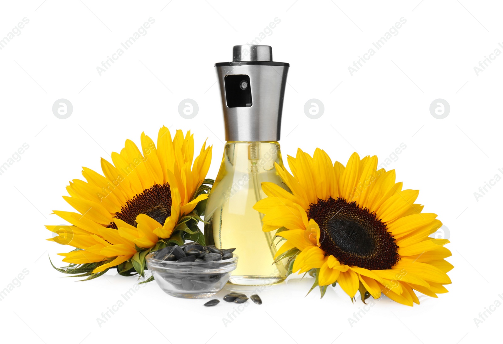 Photo of Spray bottle with cooking oil, sunflowers and seeds on white background