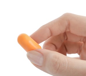 Woman holding orange ear plug on white background, closeup