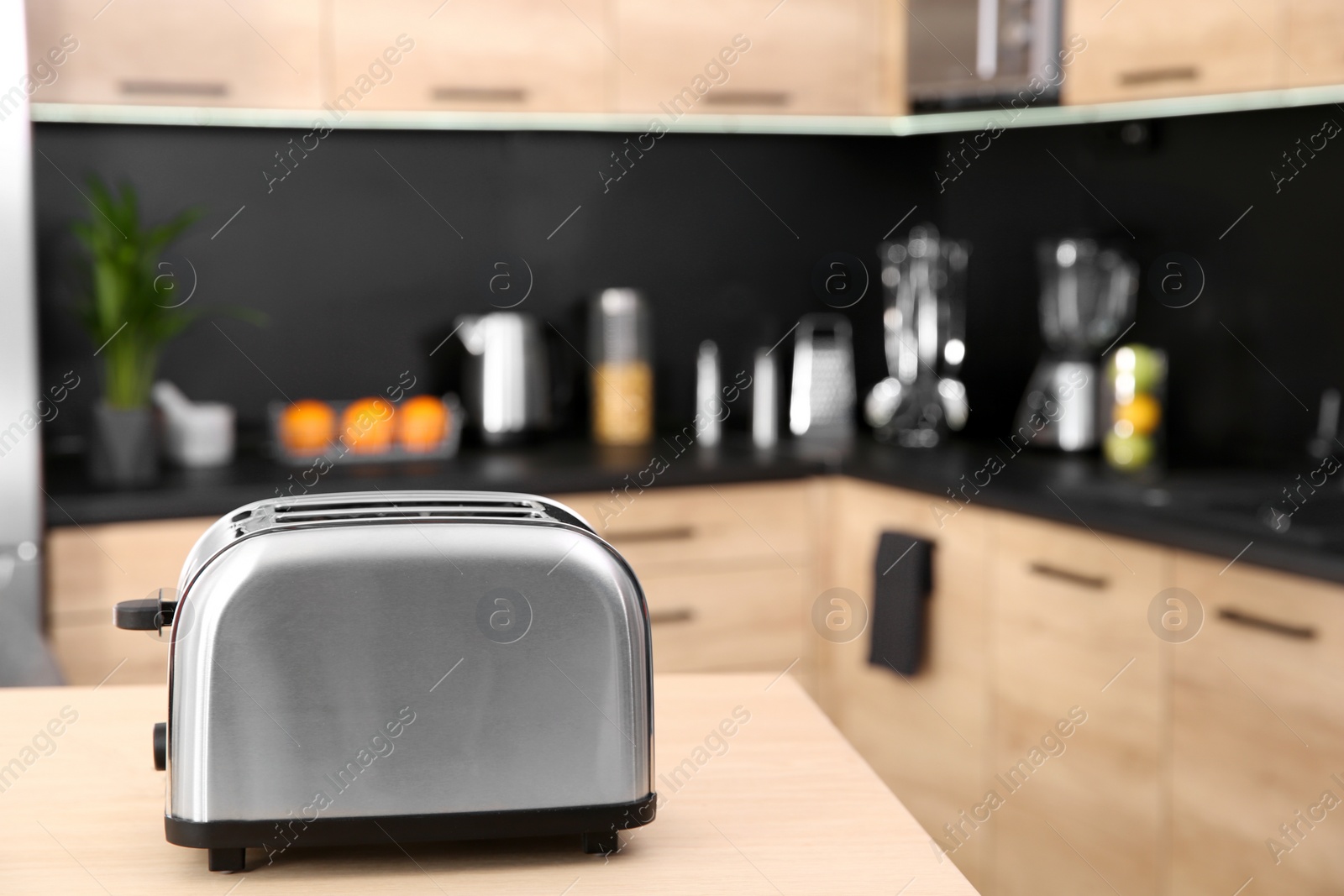 Photo of Modern toaster on table in kitchen, selective focus