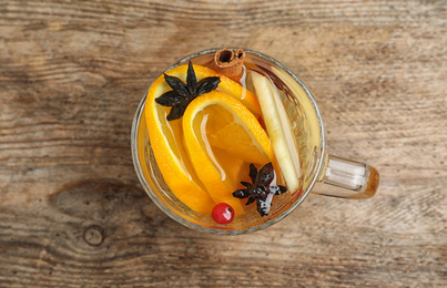 Photo of Aromatic mulled wine on wooden table, top view