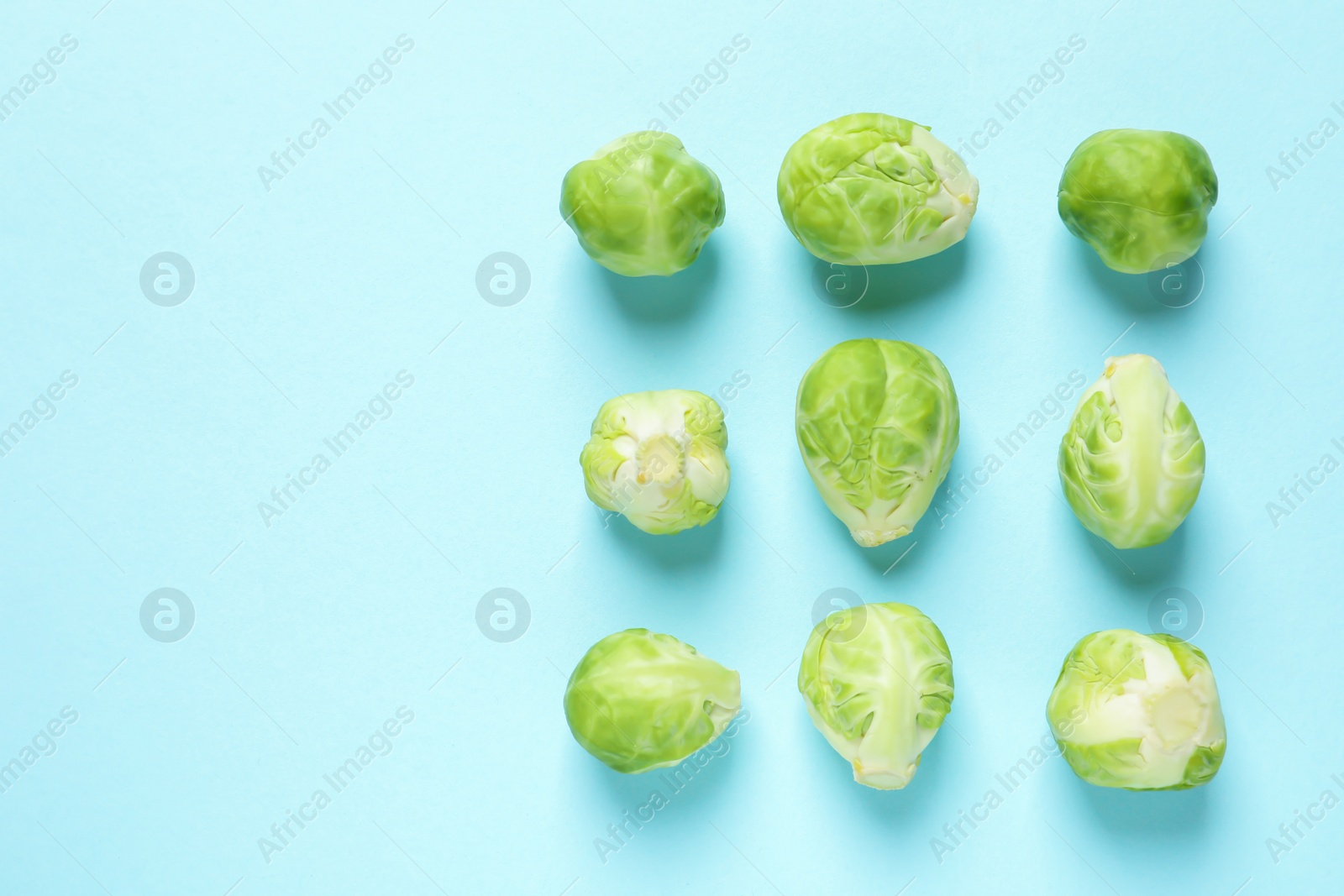 Photo of Fresh Brussels sprouts on color background, flat lay. Space for text