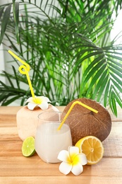 Composition with glass of coconut water on wooden table against blurred background