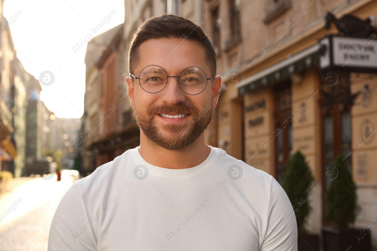 Photo of Portrait of handsome bearded man in glasses outdoors