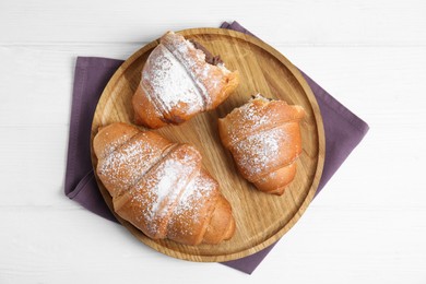 Fresh croissants with chocolate on white wooden table, top view