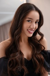 Photo of Portrait of smiling woman with curly hair on blurred background