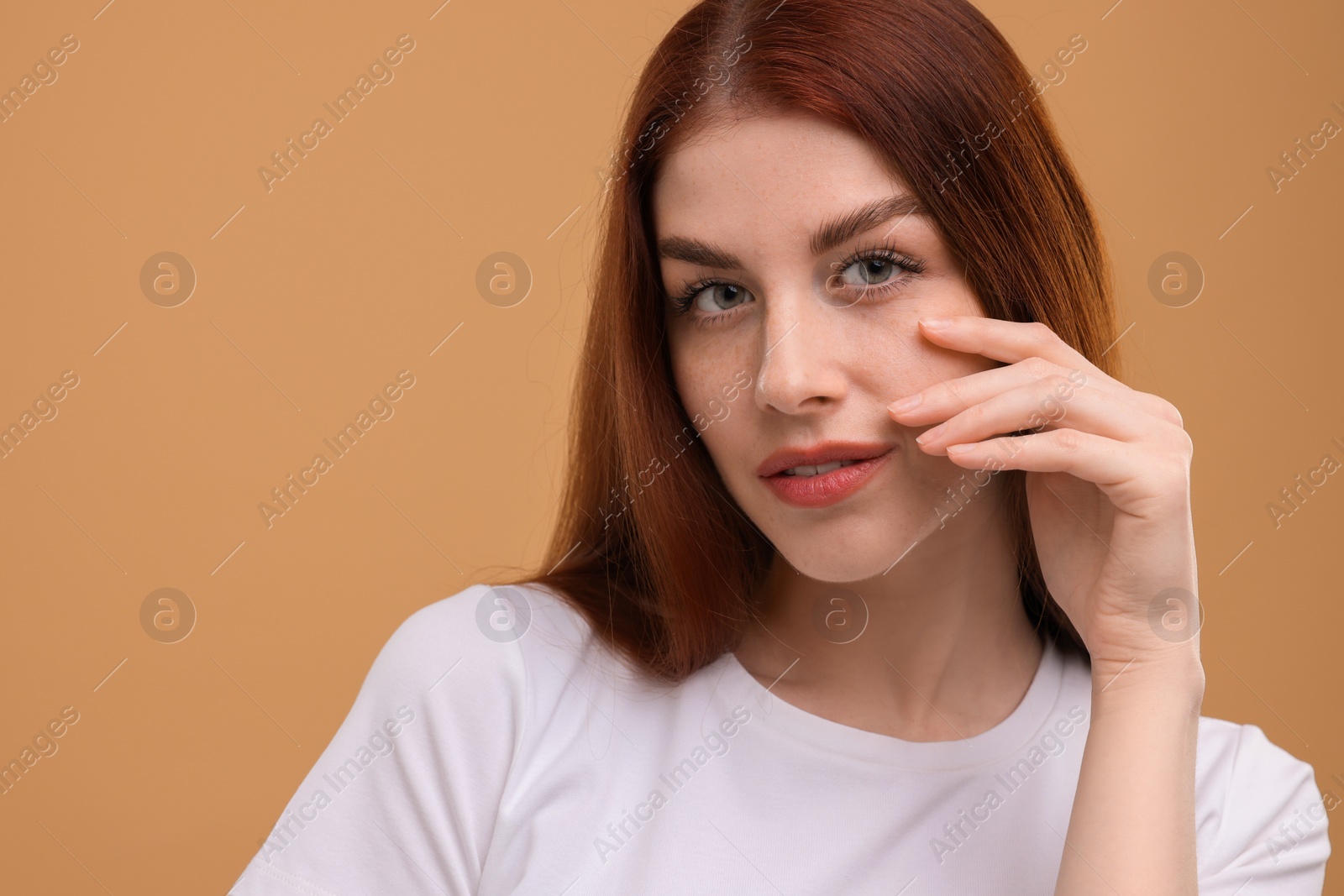 Photo of Portrait of beautiful woman with freckles on beige background. Space for text