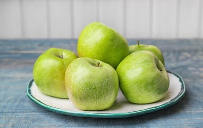 Photo of Plate with fresh green apples on wooden table