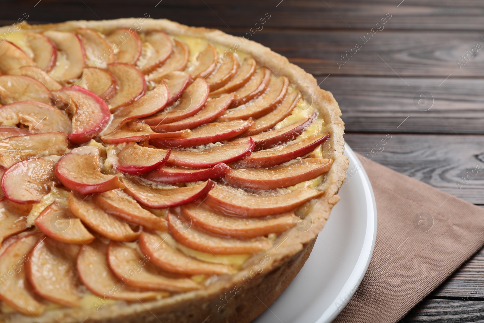 Photo of Freshly baked delicious apple pie on wooden table, closeup