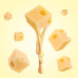 Pieces of cheese falling on yellow background