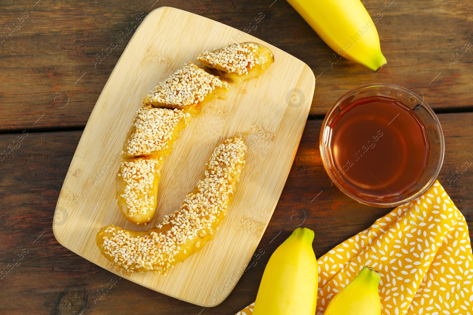 Photo of Delicious fresh and fried bananas with rum on wooden table, flat lay