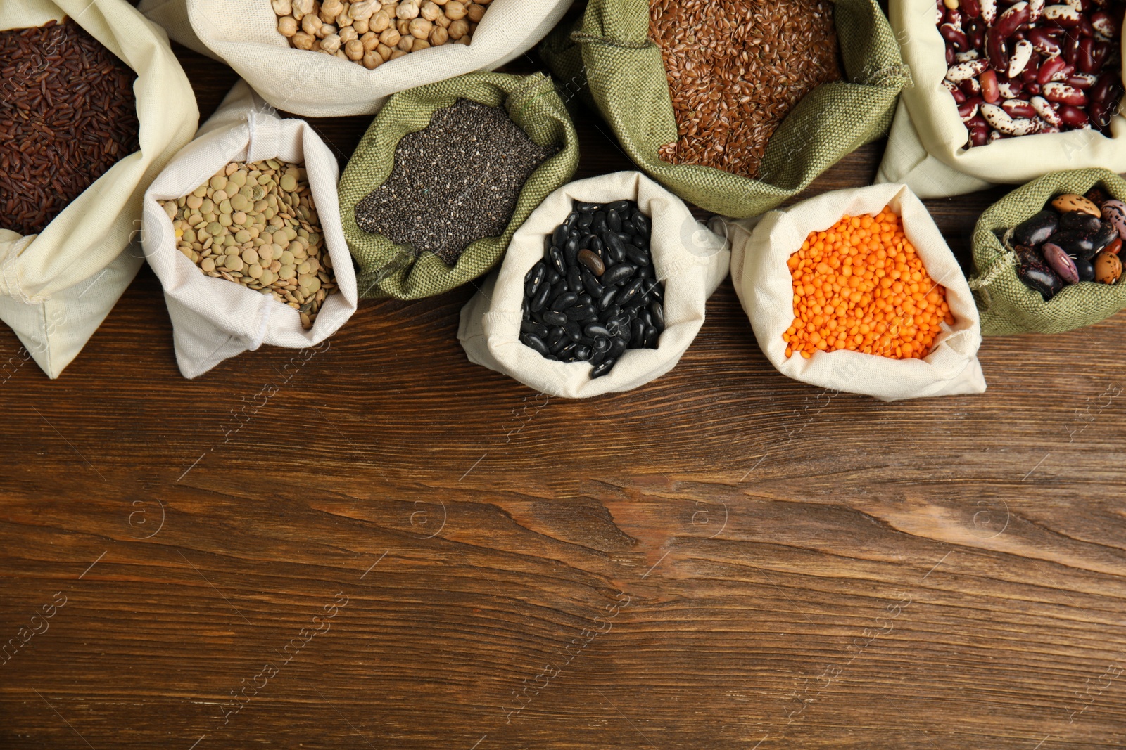 Photo of Different grains, seeds and space for text on wooden table, flat lay. Veggie diet