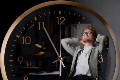 Image of Deadline management. Double exposure of man in office at night and clock