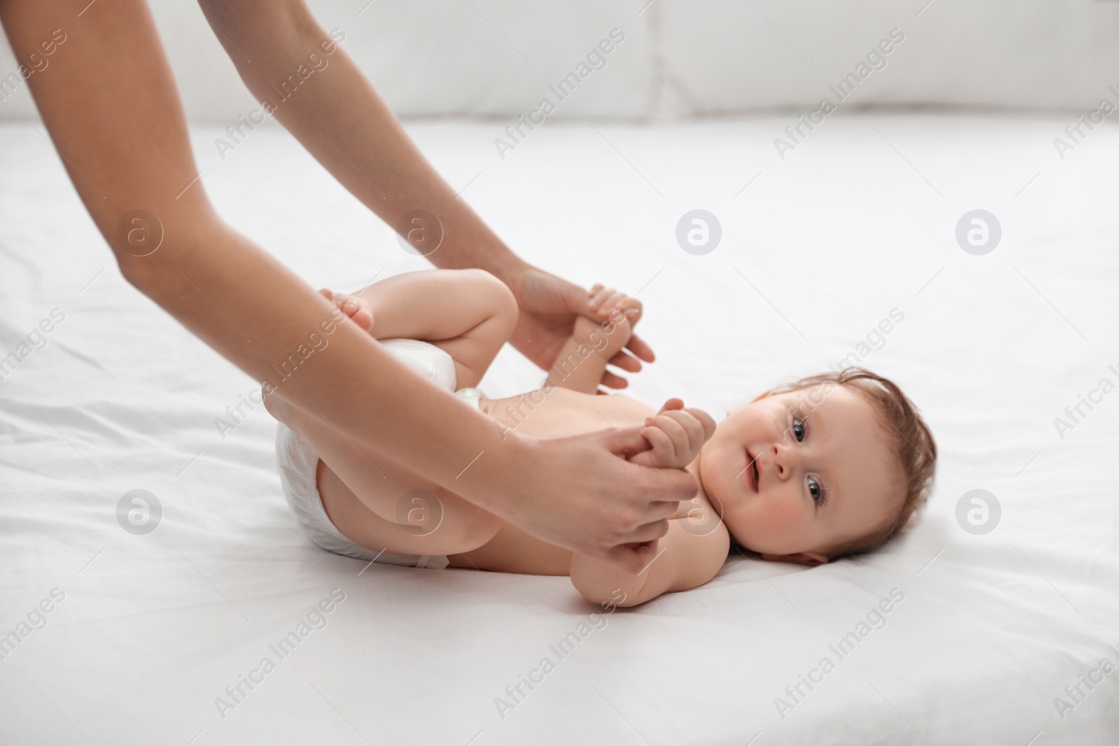 Photo of Orthopedist and cute baby on white bed