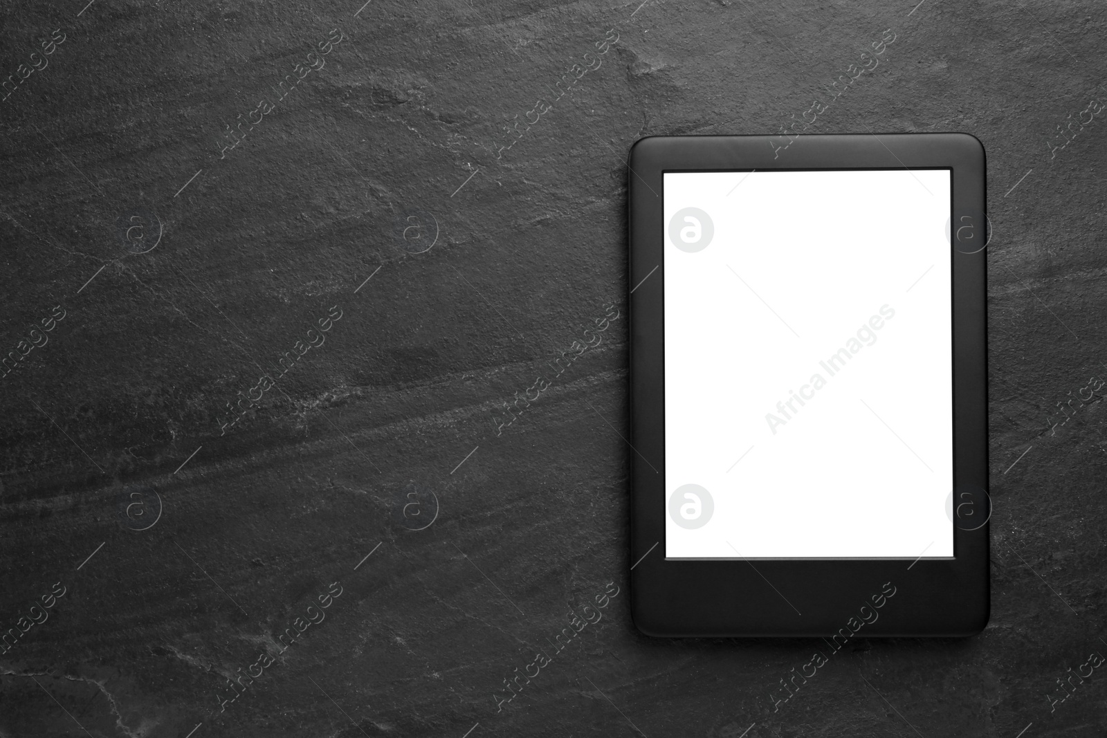 Photo of Modern e-book reader with blank screen on black table, top view. Space for text