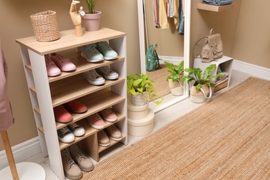 Photo of Stylish dressing room interior with shoes in storage unit