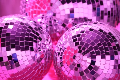 Photo of Closeup view of shiny disco balls, toned in pink