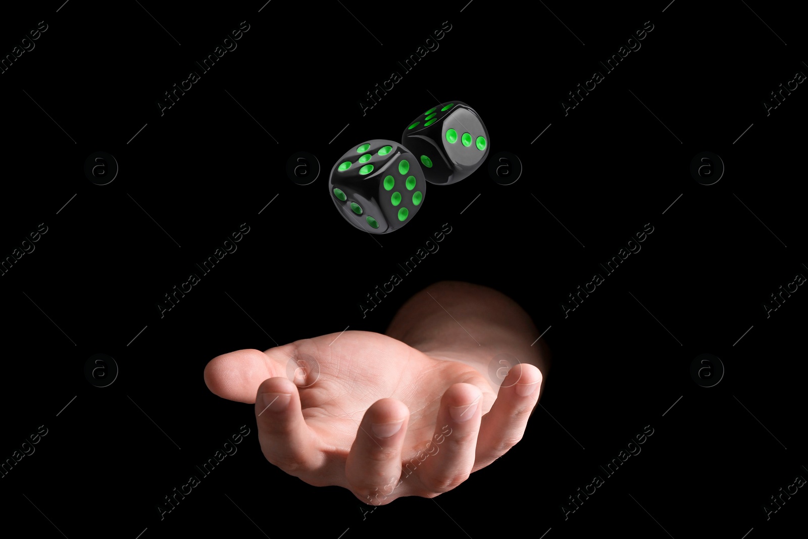 Image of Man throwing dice on black background, closeup