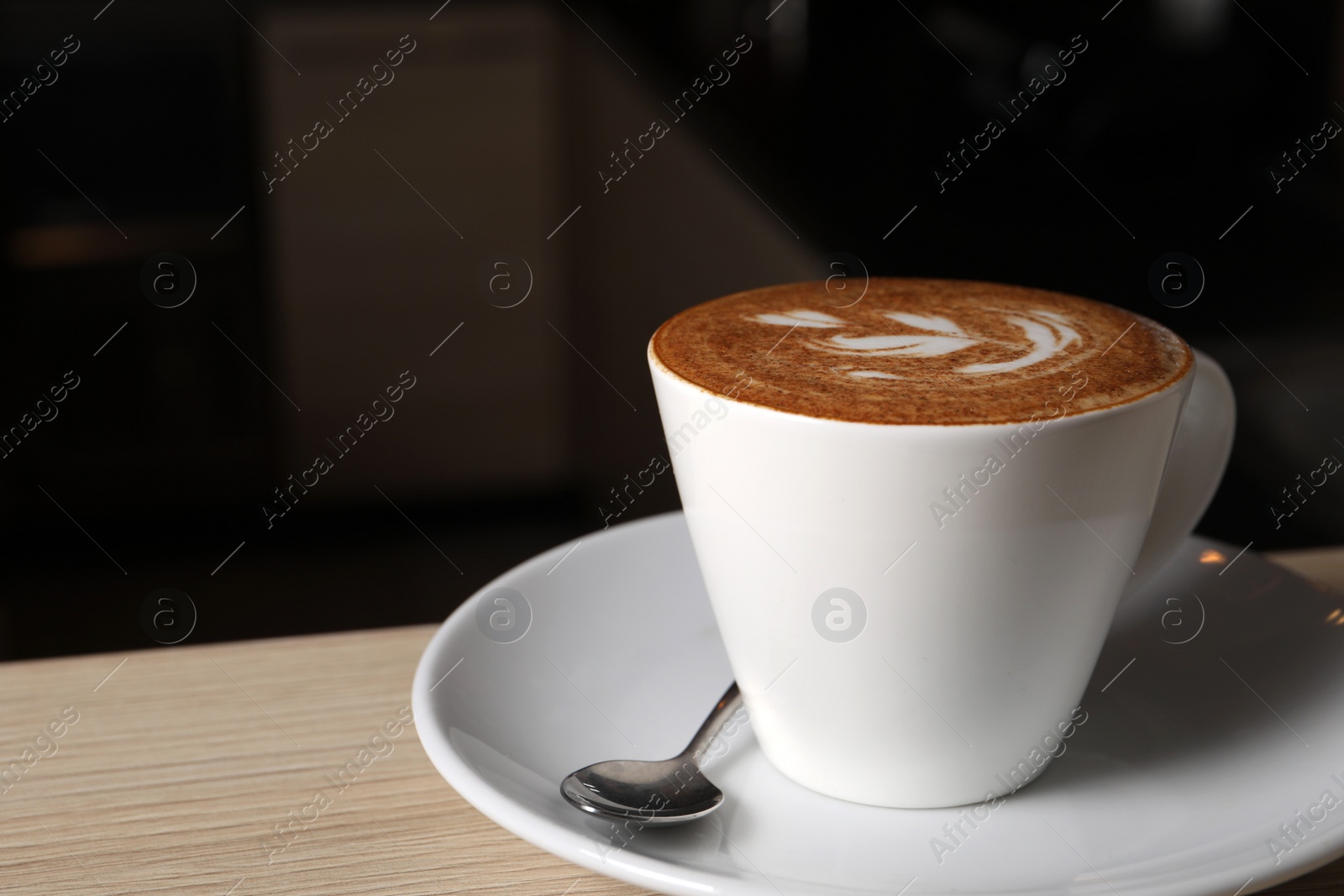 Photo of Cup of aromatic coffee on wooden table in cafe, space for text