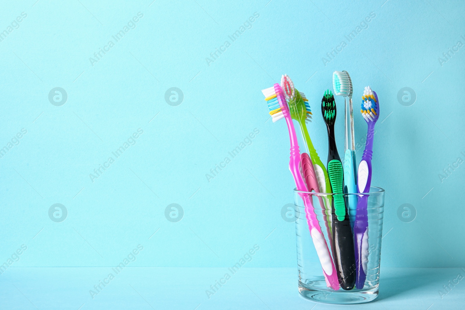 Photo of Cup with toothbrushes on color background. Dental care