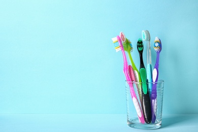 Photo of Cup with toothbrushes on color background. Dental care