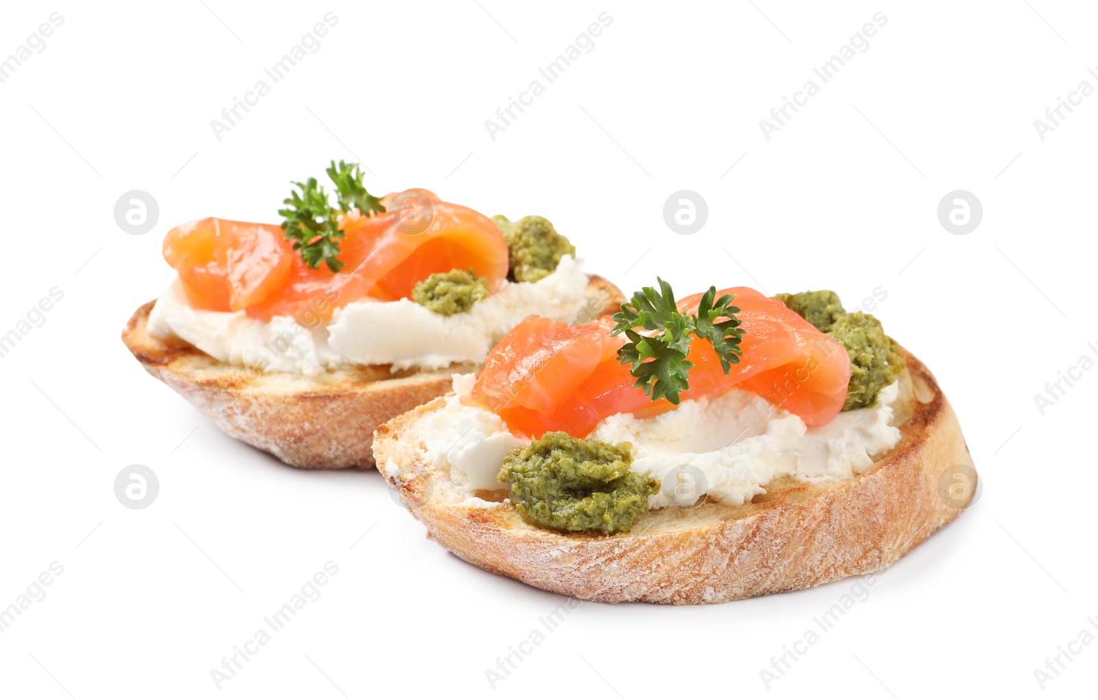 Photo of Delicious bruschettas with cream cheese, salmon and pesto sauce on white background