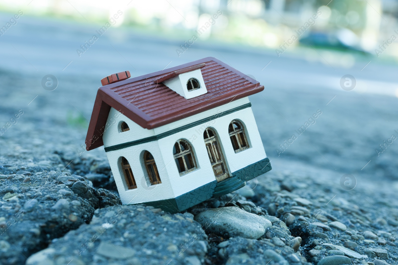 Photo of House model in cracked asphalt. Earthquake disaster