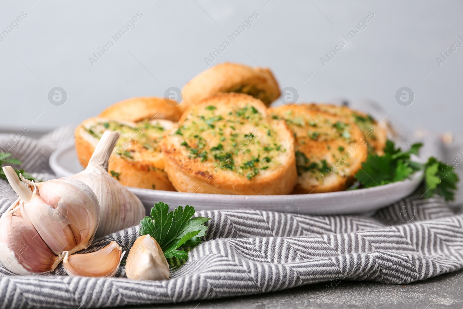 Photo of Slices of toasted bread with garlic and herbs on table