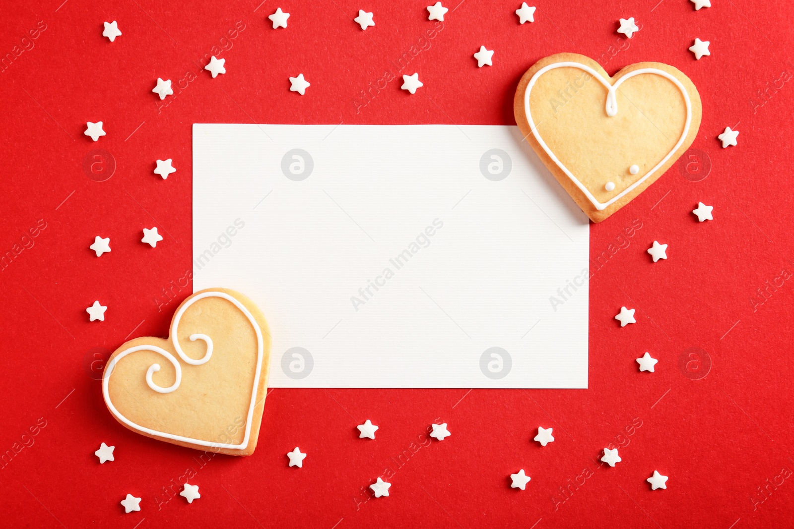 Photo of Flat lay composition with heart shaped cookies and blank card on color background, space for text