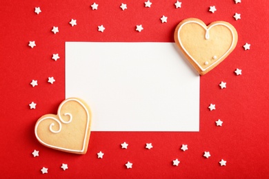 Flat lay composition with heart shaped cookies and blank card on color background, space for text