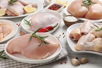 Photo of Fresh raw chicken meat and other products on white wooden table