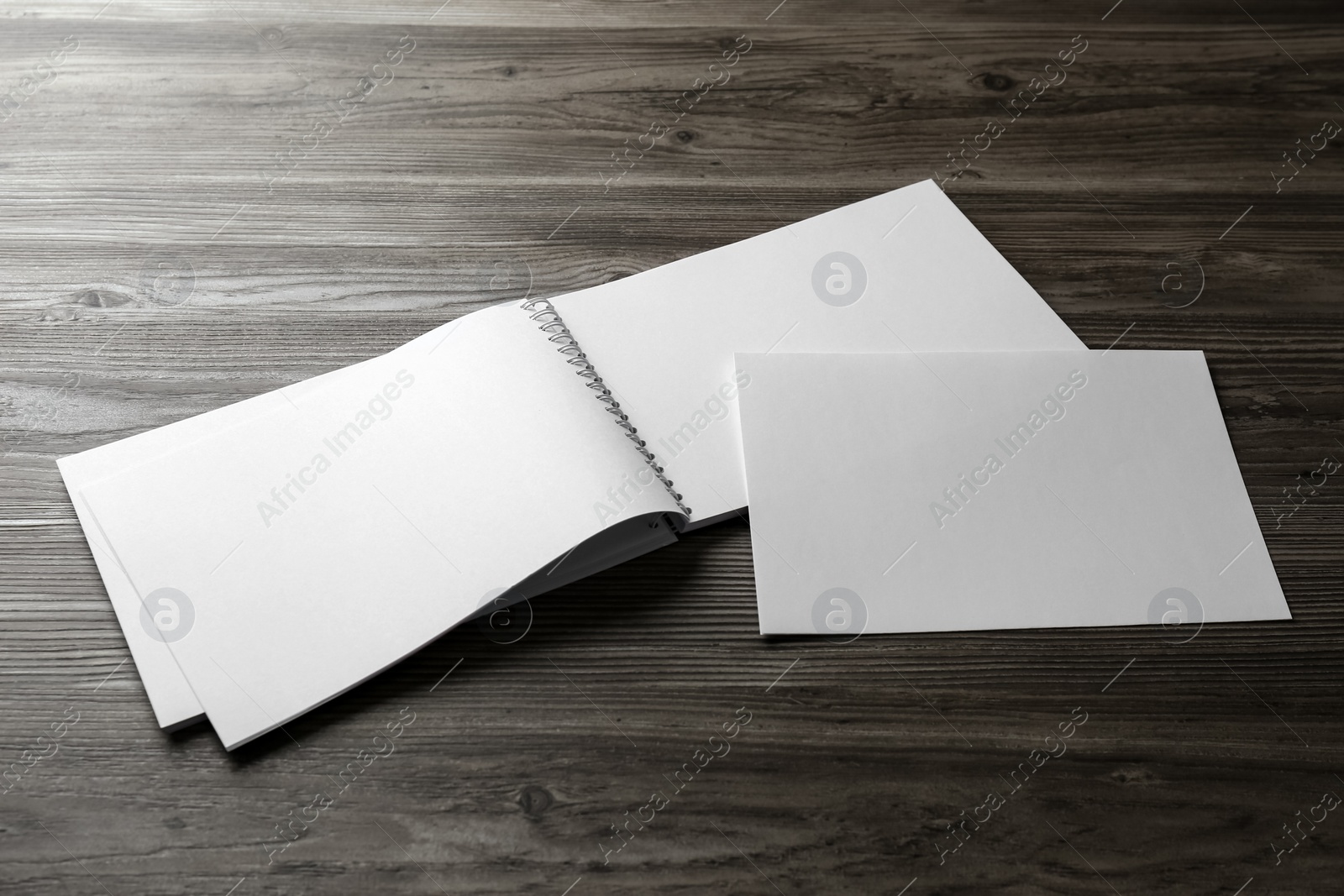 Photo of Sheet of paper and blank brochure on wooden table. Mockup for design