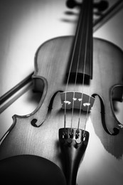 Image of Beautiful violin and bow on table, closeup. Black and white tone