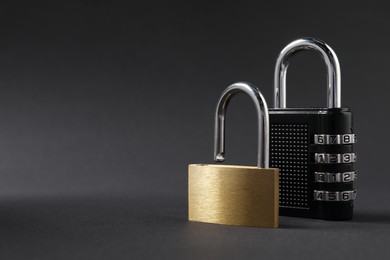 Photo of Different padlocks on black background, closeup. Space for text