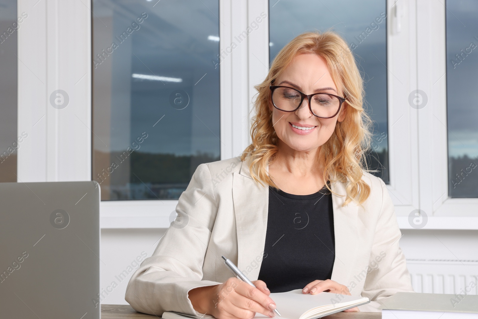 Photo of Lady boss working near laptop at desk in office. Successful businesswoman