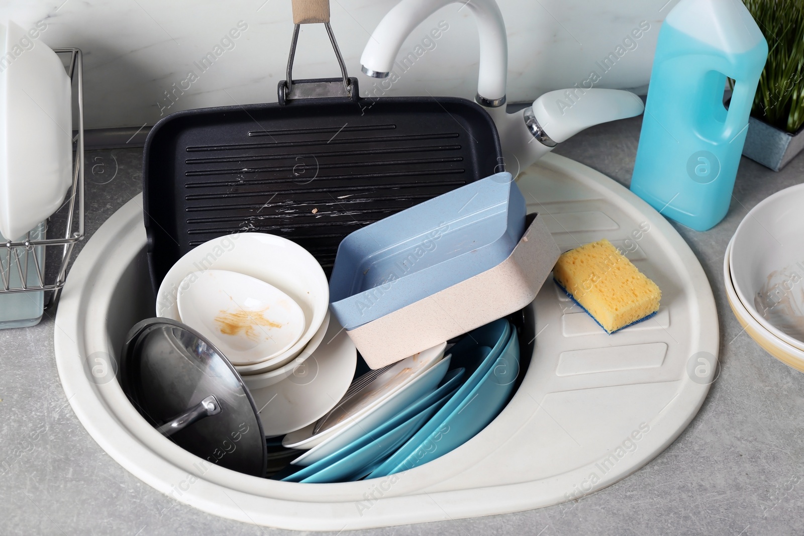 Photo of Messy pile of dirty dishes in sink