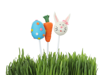 Photo of Different delicious sweet cake pops and grass on white background. Easter holiday