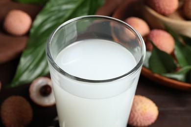 Photo of Freshly made lychee juice on wooden table, closeup