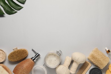 Bath accessories. Flat lay composition with personal care products on light grey background, space for text