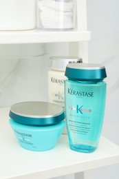 Photo of MYKOLAIV, UKRAINE - SEPTEMBER 07, 2021: Kerastase hair care cosmetic products on white shelf in bathroom